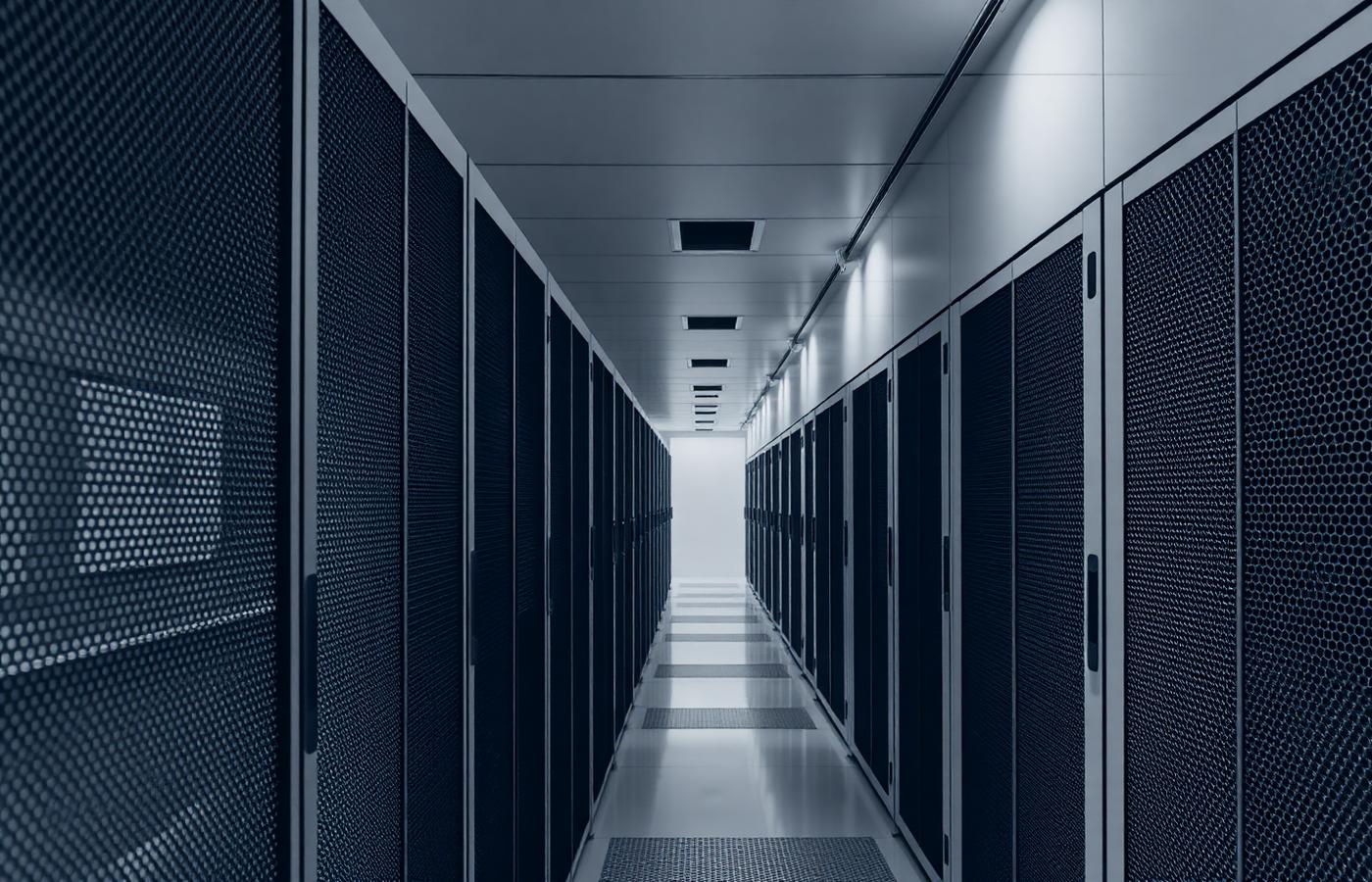 Monochrome view along a corridor of data centre server racks